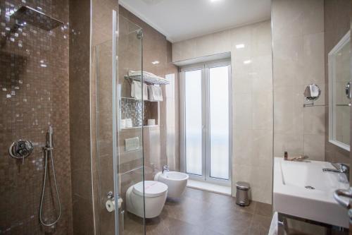 地拉那地拉那竞技场酒店的带淋浴、卫生间和盥洗盆的浴室