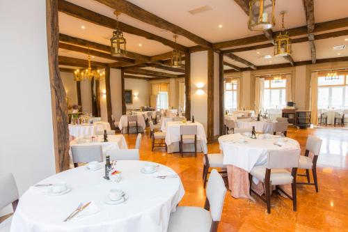里瓦德奥里巴德欧旅馆的一间设有白色桌椅的用餐室