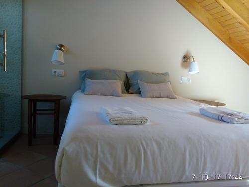 普罗阿萨Tu casita de la Senda del Oso的卧室配有带毛巾的大型白色床