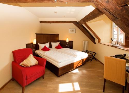 兰施图尔奥姆勒餐厅酒店的一间卧室配有一张床和一张红色椅子