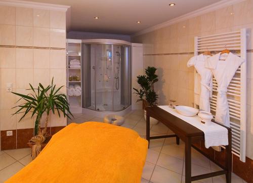兰施图尔奥姆勒餐厅酒店的带淋浴、桌子和水槽的浴室