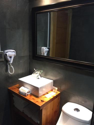 卡斯特鲁Mangata Hotel Low Cost的一间带水槽、镜子和卫生间的浴室