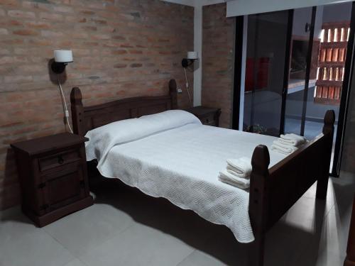 圣安娜Los cardenales 2的一间卧室设有一张床和砖墙