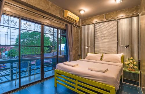 奥南海滩萨尼姆旅舍的一间带大床的卧室和一个阳台