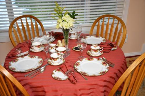 夸利库姆海滩茶壶套住宿&早餐酒店的一张桌子,上面有盘子和玻璃杯,花瓶