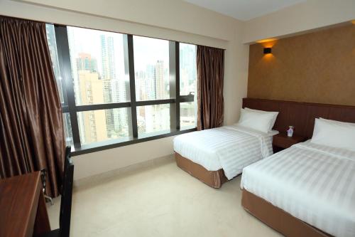 香港伯惠酒店的酒店客房设有两张床和大窗户。