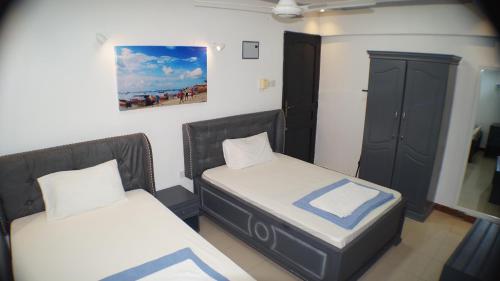 达累斯萨拉姆Econo Lodge的一间设有两张床的房间和一个橱柜