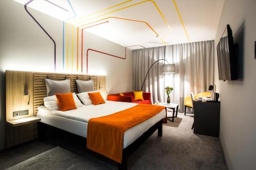 华沙宜必思尚品华沙酒店的酒店客房,配有一张带橙色毯子的床