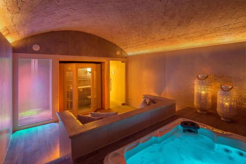 罗马皮科洛伯格酒店的一间带按摩浴缸和镜子的浴室
