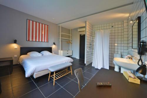 维耶尔宗Logis - Hotel Restaurant La Mire的一间卧室配有一张床,浴室设有水槽