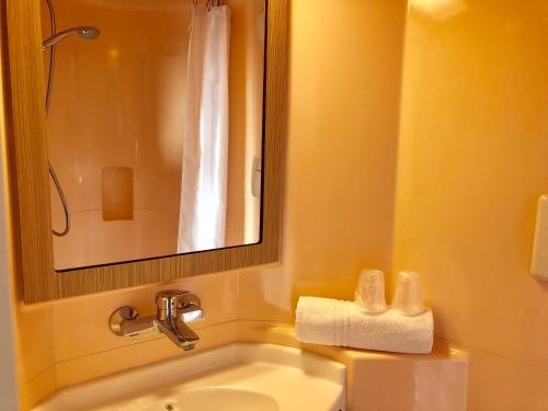 佩皮尼昂南佩尼皮昂普瑞米尔经典酒店的一间带水槽、镜子和卫生间的浴室