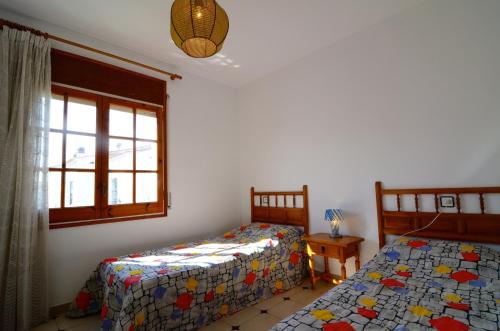 莱斯卡拉Casa la Flor的一间卧室设有两张单人床和一个窗户。