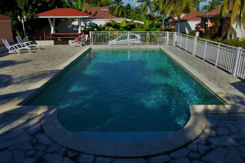 圣弗朗索瓦Village Honoré的庭院里的一个蓝色海水游泳池