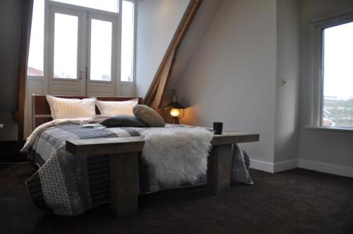 吕伐登Villa Kakelbont的一间卧室配有一张带长凳和窗户的床。