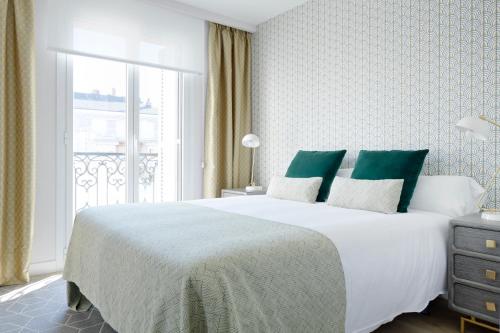 圣塞瓦斯蒂安La Concha Attic by FeelFree Rentals的卧室配有带绿色枕头的大型白色床