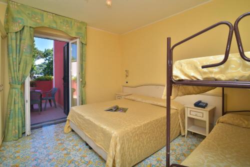 伊斯基亚弗朗卡酒店的一间带两张双层床的卧室和一个阳台
