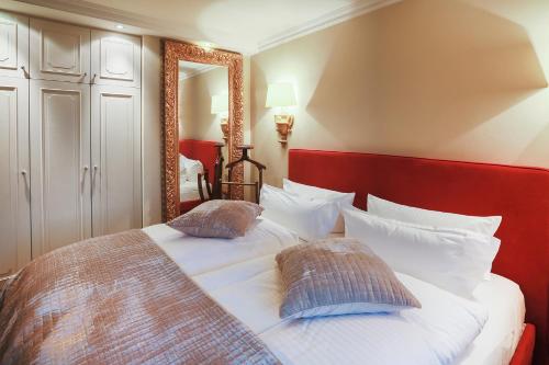 曼克玛肖Sönshorn 8 Rechts的一间卧室配有一张带红色床头板和镜子的床