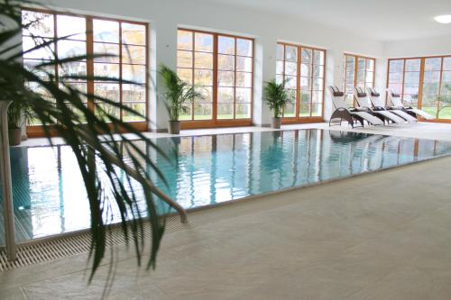 埃本塞霍施特劳恩湖萨尔茨卡默古特酒店的大型室内游泳池设有椅子和窗户