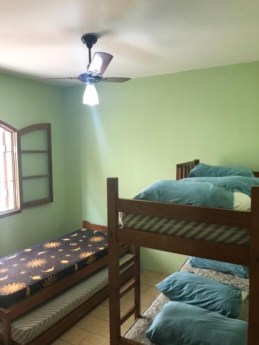 乌巴图巴Chalés Beto Amá的一间卧室设有两张双层床和吊扇