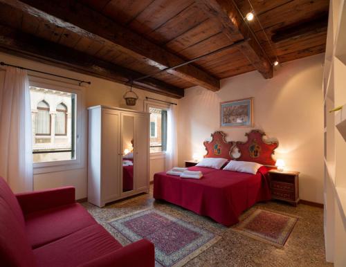 威尼斯圣萨沃罗公寓的一间卧室配有红色的床和一张沙发