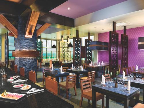 莫雷洛斯港Generations Riviera Maya Family Resort - More Inclusive的餐厅设有桌椅和紫色墙壁
