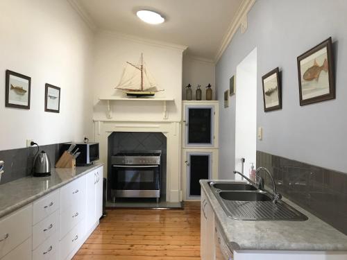 金斯科特Armadale House - Kingscote的一个带水槽和壁炉的厨房
