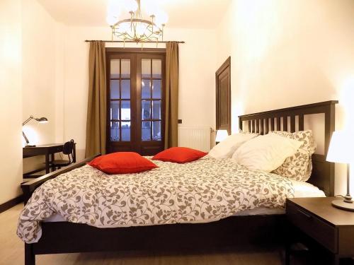 沙勒罗瓦Maison Roosevelt - Charleroi Airport - Ideal Families的一间卧室配有一张带两个红色枕头的床