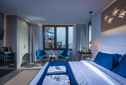 海若克利欧Lavris City Suites的酒店客房设有一张蓝色调的大床。