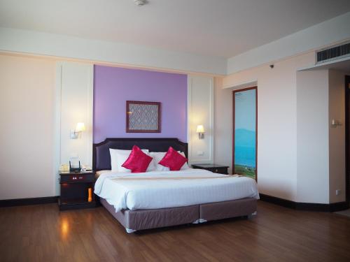 坤敬祡润芳尼孔敬酒店的一间卧室配有一张带红色枕头的大床