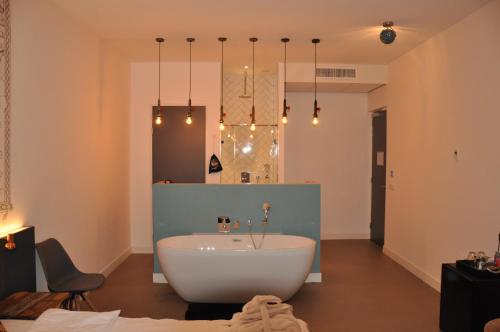 艾默伊登劳乌安娜德卡德酒店的浴室配有白色浴缸和镜子