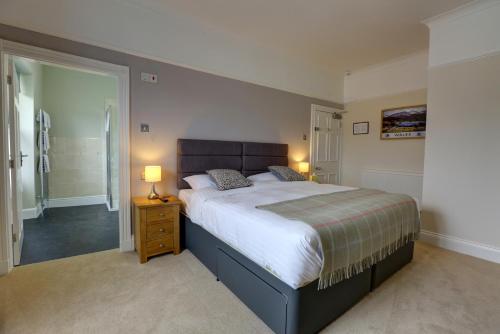 布雷肯The Grange Guest House的一间卧室设有一张大床和一个步入式淋浴间。