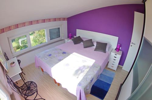 法扎纳Leni的一间卧室设有一张紫色墙壁的大床
