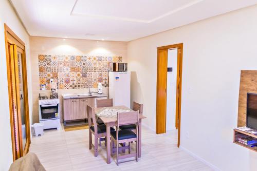 新彼得罗波利斯Cantinho do Sossego的厨房配有桌椅和冰箱。