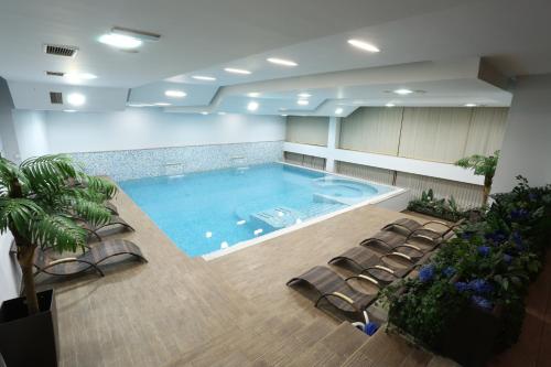 泽尼察Hotel Zenica的一个带椅子的房间的大型游泳池