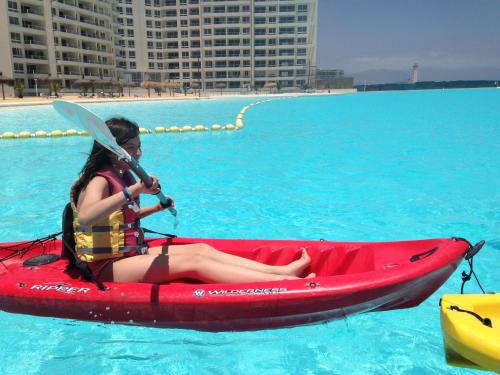 拉塞雷纳Departamento Resort Laguna del Mar的坐在水里红皮艇上的女人