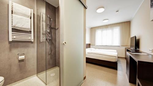 纽伦堡24Seven Hotel Nürnberg的带淋浴的浴室和1间带1张床的卧室