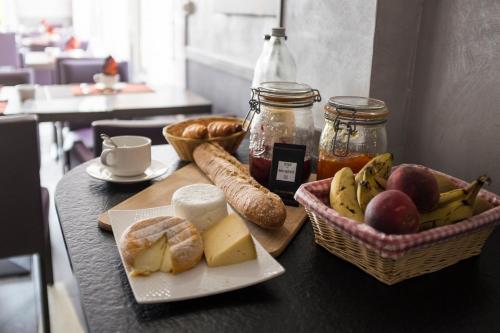 Le Nouvion-en-ThiéracheHotel Restaurant La Paix的一张桌子,上面放着一盘面包和一篮水果