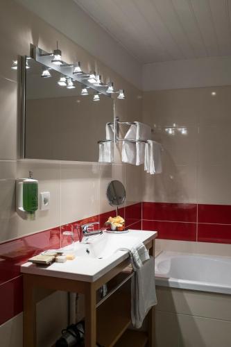 Le Nouvion-en-ThiéracheHotel Restaurant La Paix的浴室配有盥洗盆、镜子和浴缸