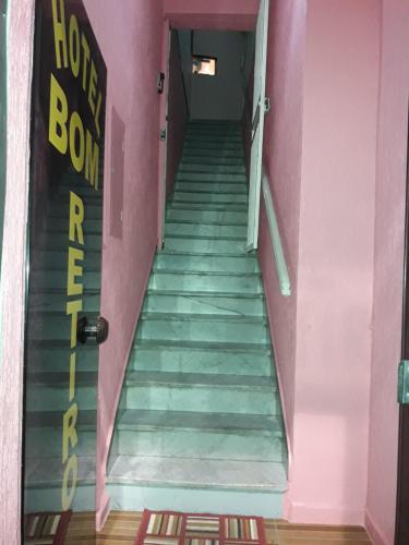圣保罗Hotel bom retiro的粉红色的房间,有门,有楼梯