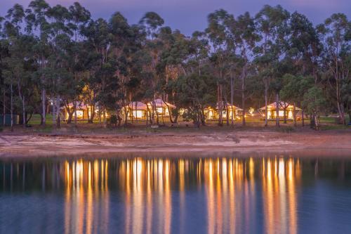 Cowaramup奥里奥贝洛湖畔格拉姆皮恩酒店的夜间从水面上欣赏小屋的景色