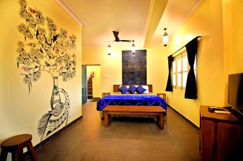 乌代浦Oolala - Your lake house in the center of Udaipur的卧室配有一张床,墙上挂有绘画作品