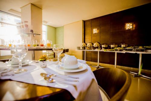 帕图布兰库Hotel San Pietro的一张桌子,上面有白色的盘子和餐具