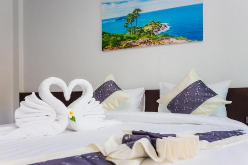 蔻立The Retreat Khaolak Resort - SHA Extra Plus的两只天鹅用毛巾制成,坐在两张床上
