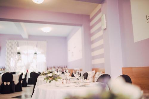 萨尔索马焦雷泰尔梅精英酒店的一间设有白色桌椅的用餐室