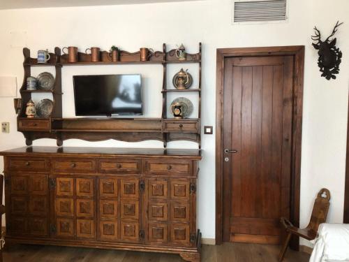 摩德纳迪-坎皮格里奥Appartamento的木柜上的电视,放在带门的房间