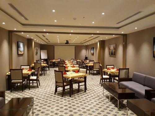 Al QunfudhahBeach Inn的一间在房间内配有桌椅的餐厅