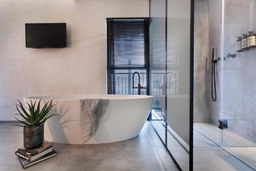 特拉维夫维拉酒店的带电视的浴室设有大浴缸