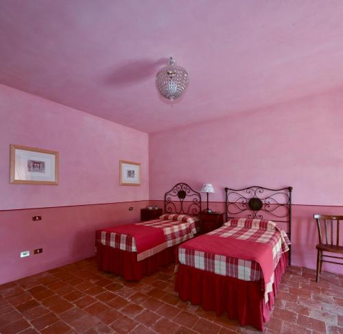拉莫拉拉特烈迪皮埃弗拉沃加利纳酒店的一间卧室设有两张床,墙壁粉红色