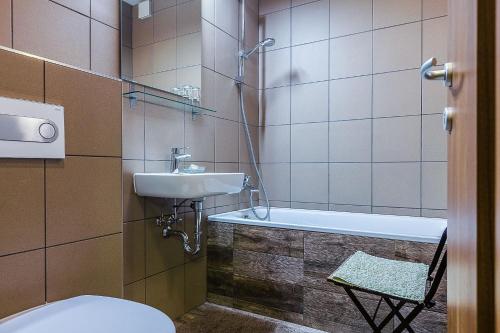 EgerbaktaEzererdő Vendégház的浴室配有盥洗盆、卫生间和浴缸。