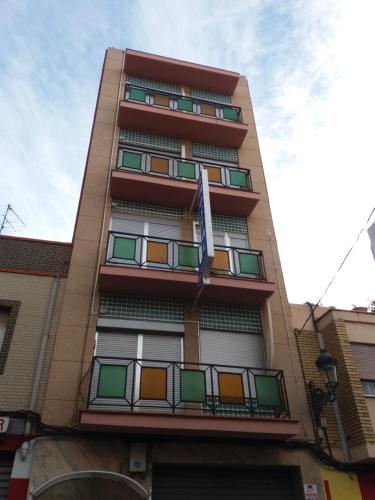 帕特纳皮拉丽卡旅馆的一座高大的建筑,有五颜六色的窗户和旗帜